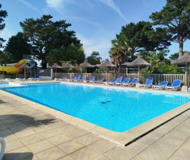 Piscine extérieure avec transats et toboggan au Mobil home cosy dans camping 4 étoiles