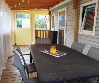 Terrasse couverte avec table et chaises du mobil home cosy dans camping 4 étoiles