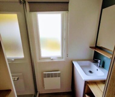 Salle d'eau compacte avec lavabo et rangements du Mobil home au Camping 4 étoiles