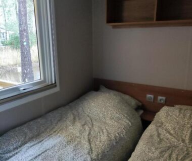 Chambre avec deux lits et fenêtre dans le mobil-home 6 à 8 personnes 40m2