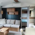Séjour avec canapé coin repas et chambre visible dans le Mobil-home dans camping 4 étoiles 6 à 8 personnes 40m2