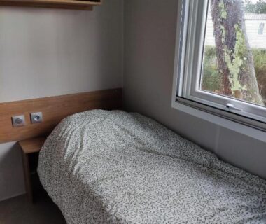 Chambre avec lit simple et fenêtre dans le mobil-home du camping 4 étoiles 6 à 8 personnes 40m2