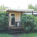 Terrasse couverte avec chaises et haies du Mobil-home dans le calme du Domaine de Lanniron R24