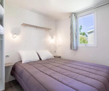 Chambre avec lit double et fenêtre du mobil-home de Laura et Angélique au camping Le Neptune