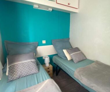 Chambre avec deux lits simples et rangements dans le Mobil home de charme à la mer