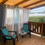 Terrasse couverte avec deux fauteuils et table du Mobil home de charme à la mer