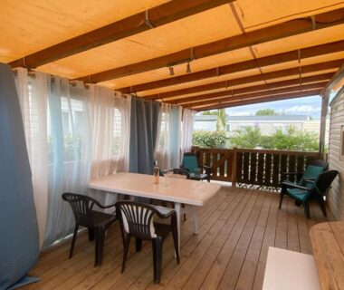Terrasse couverte avec table et chaises du Mobil home de charme à la mer