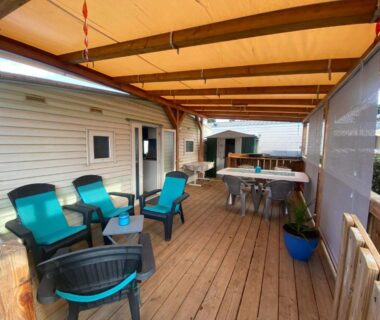 Terrasse couverte avec salon et coin repas du Mobil home de charme à la mer