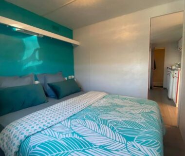 Chambre avec lit double et linge turquoise dans le Mobil home de charme à la mer