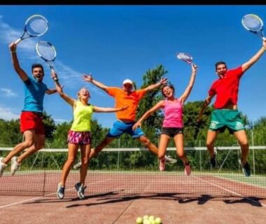 Court de tennis avec cinq personnes sautant et raquettes levées au Mobil-home du Lac Mimizan