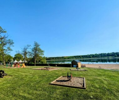 Bord du lac avec pelouse et aire de jeux au Mobil-home emplacement 1