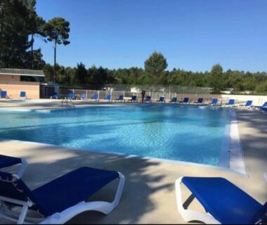 Piscine extérieure bordée de transats au Mobil home familial N 211