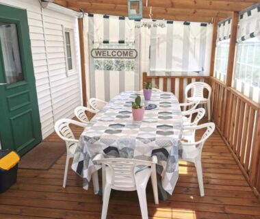 Véranda couverte avec table et chaises dans le mobil home familial 4-6 pers accès piscine et aire de jeux