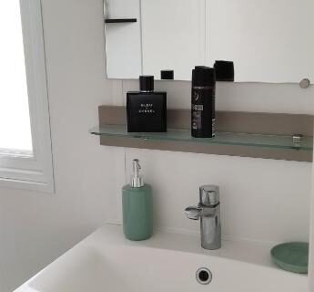 Salle de bain avec lavabo miroir et crochets du Mobil home famille Calazel
