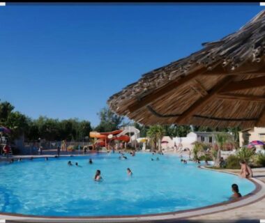 Piscine extérieure avec toboggans et parasol au Mobil home famille Calazel