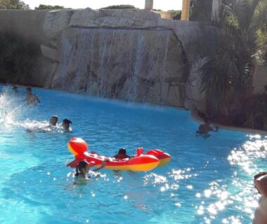 Piscine bleue avec nageurs et bouée au mobil home Florida au camping les Cigales