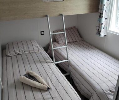 Chambre avec deux lits simples et lit superposé dans le mobil home le Sunny