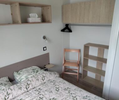 Intérieur chambre avec lit double et rangements dans le mobil home le Sunny