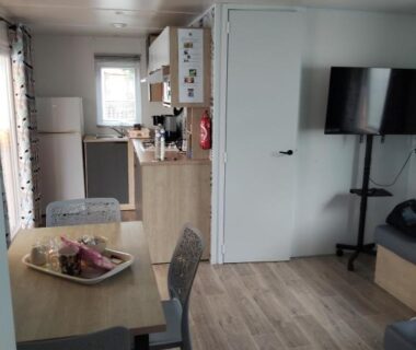 Séjour avec kitchenette et télévision dans le mobil home le Sunny