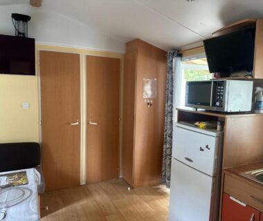 Intérieur avec kitchenette réfrigérateur microondes et télévision du mobil home les sables d'or