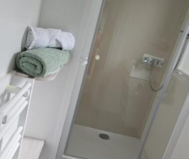 Salle de bains avec cabine de douche et serviettes dans le mobil home Les Sables d'or