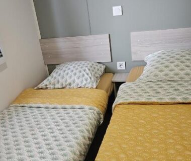 Chambre avec deux lits simples et rangements dans le mobil home les sables d'or