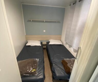 Chambre avec deux lits simples et table de chevet du Mobil-home narbonne plage
