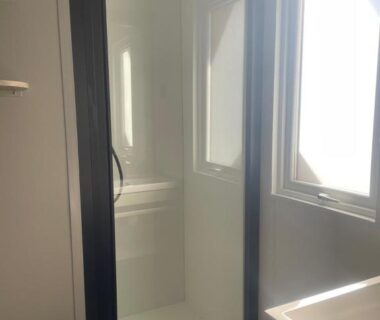Salle de bain avec douche et fenêtre dans le mobil-home neuf 6 à 8 pers au Camping Les Palmiers