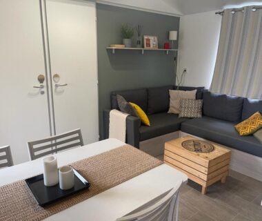 Salon et coin repas dans le mobil home au Cap-Ferret Camping les Viviers au bord du bassin