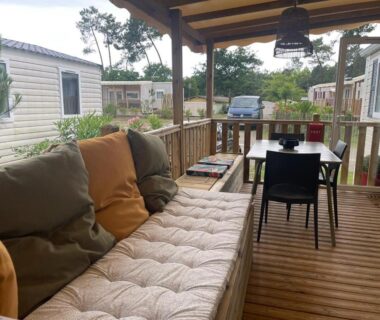 Terrasse en bois avec canapé et table dans le mobil home paisible au Cap-Ferret au Camping les Viviers