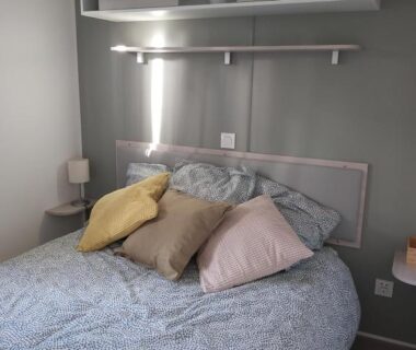 Intérieur chambre avec lit et coussins du Mobil home paisible au Cap-Ferret