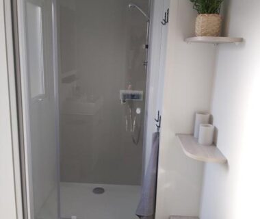 Salle de douche avec cabine et étagères dans le mobil home paisible au Cap-Ferret Camping les viviers