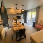Séjour avec coin repas canapé et cuisine ouverte du Mobil home plage 4 étoiles