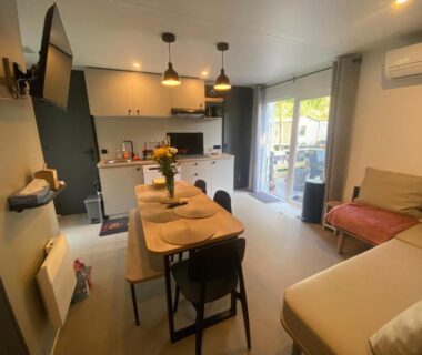 Séjour avec coin repas canapé et cuisine ouverte du Mobil home plage 4 étoiles