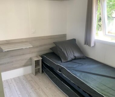 Chambre avec lit simple et rangement dans le Mobil home près de l étang