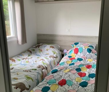 Chambre avec deux lits et rangements dans le Mobil home près de l'étang