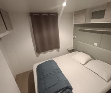 Chambre double avec lit et rangement dans le mobil home prestations DELUXE 3ch climatisé