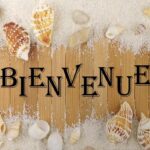 Planche en bois avec coquillages et sable au Mobil home proche du paradis des plages