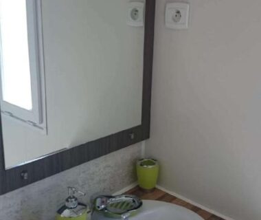 Lavabo avec miroir et gobelets verts dans le Mobil home récent clim 3ch Camping3* piscine