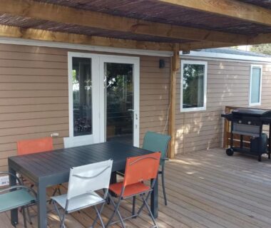 Terrasse en bois avec table chaises et barbecue du mobil-home récent de 2025 à Camping Domaine l'Ile d'Or