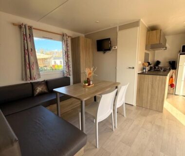 Intérieur avec coin salon et kitchenette du mobil home spacieux 5 personnes à 15 min de Concarneau