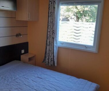 Chambre avec lit et fenêtre dans le Mobil home sur Carnac