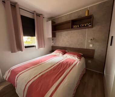 Chambre intérieure double avec lit rayé dans le mobil home sur le bassin d'Arcachon