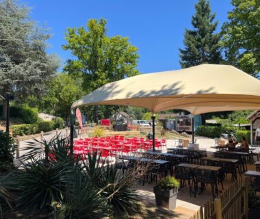 Terrasse extérieure avec tables et chaises sous tonnelle du Mobil home tout confort