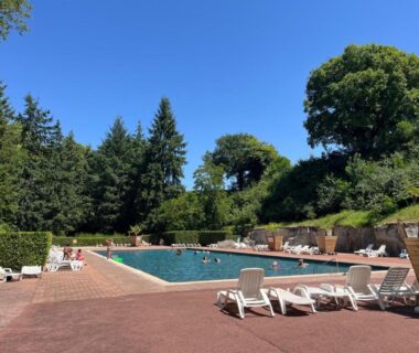 Piscine extérieure avec chaises longues dans un cadre boisé du Mobil home tout confort