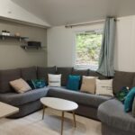 Séjour avec canapé d'angle et table basse dans le Mobil-home tout confort à 300m de l’océan