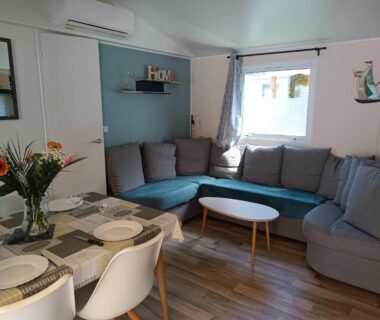 Intérieur salon avec canapé et coin repas du mobil-home tout confort Camping Mar Estang à Canet-en-Roussillon