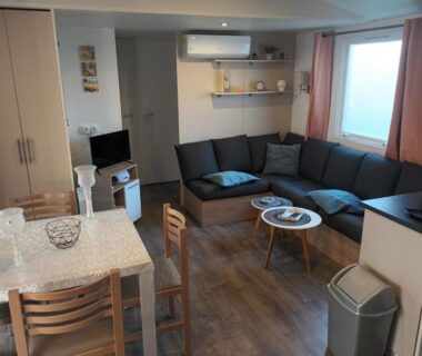 Intérieur avec salon canapé et coin repas dans le Mobil home tout confort Canet Plage