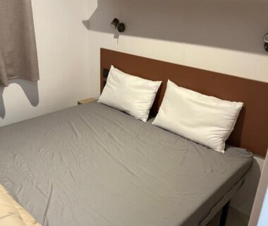 Chambre avec lit double et étagères dans le Mobil home tout confort côte bleue