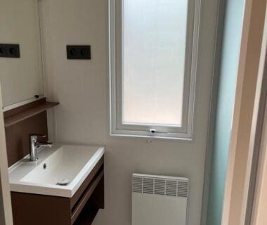 Salle de bain avec lavabo et fenêtre dans le Mobil home tout confort côte bleue